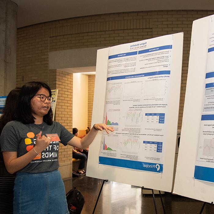 Woman presents data on poster boards